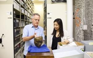 professor examines mask with student