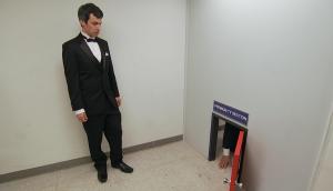 Nathan Fielder stands next to a tiny door