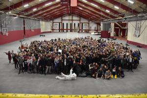 A large group of students gathered behind a polar bear mascot